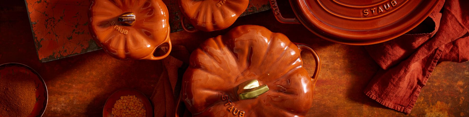 A white cast iron pumpkin dutch oven on a table.