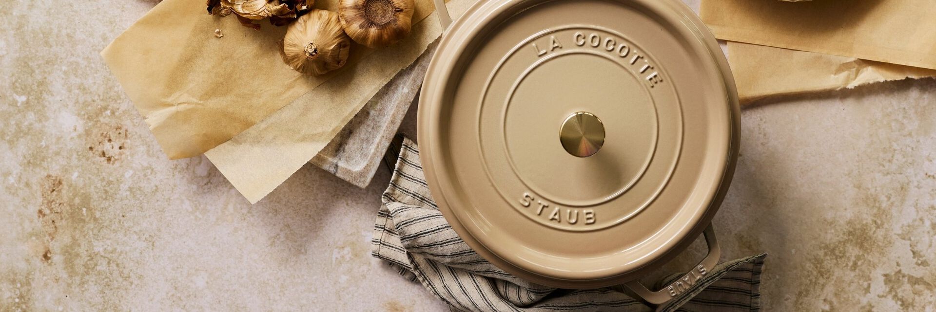 Grenadine Staub Dutch oven on a burgundy, marble counter.